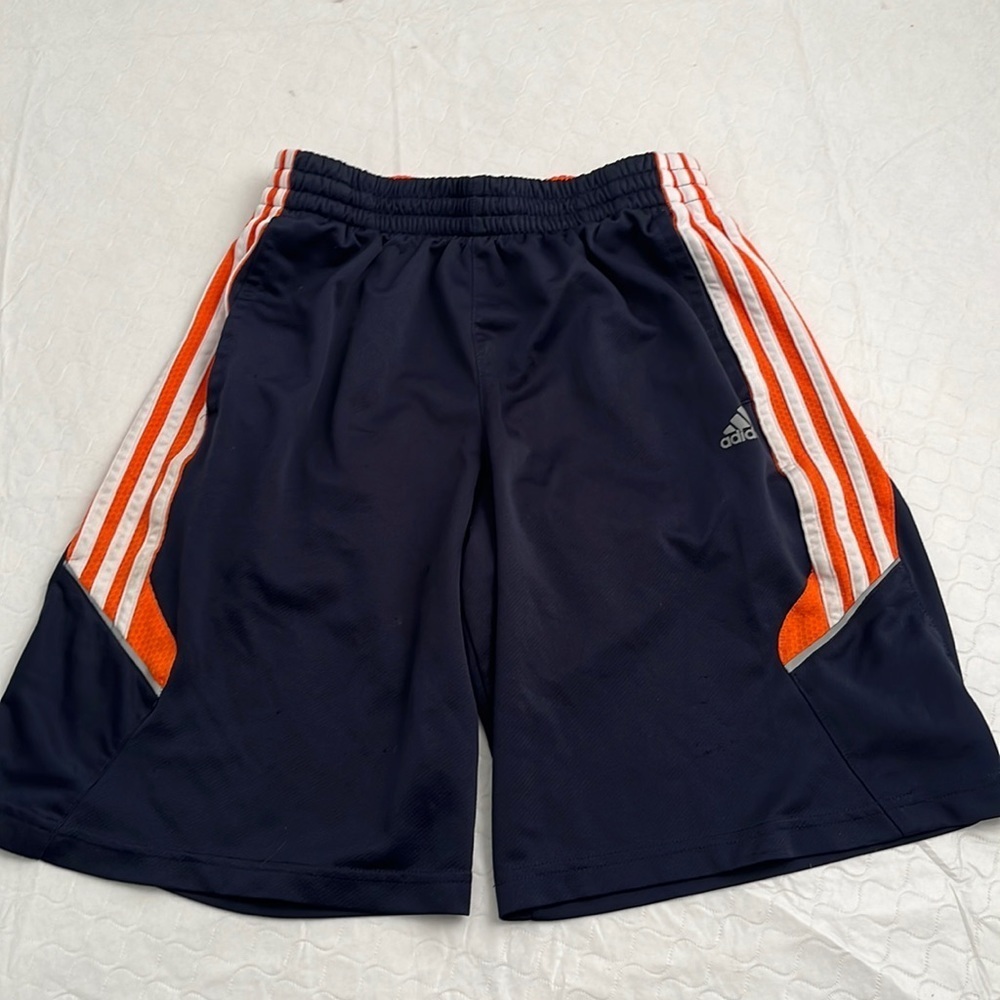 Adidas navy athletic shorts with signature white stripes and orange mesh